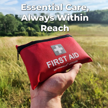 Red first aid kit held in a hand with a scenic background