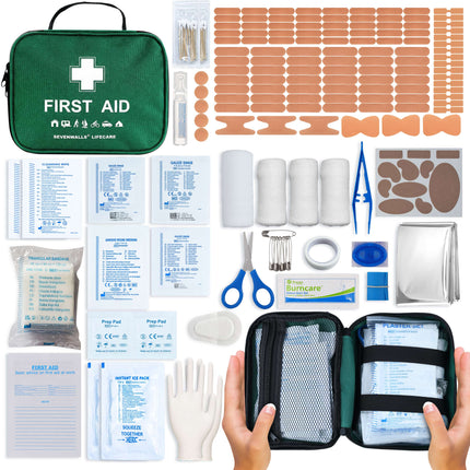 First aid kit with various supplies including bandages, scissors, and packets on a white background.
