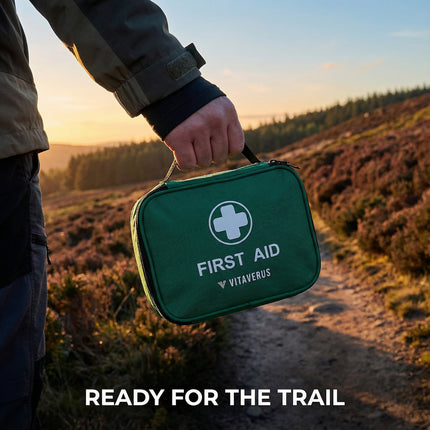 Person holding a green first aid kit with Vitaverus branding in a natural setting.