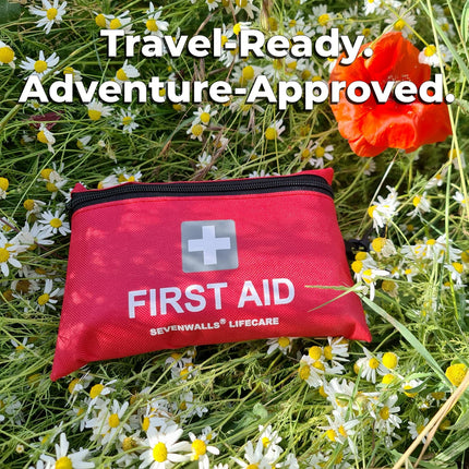 Red first aid kit with 'SevenWalls Lifecare' branding on a grassy background with flowers.