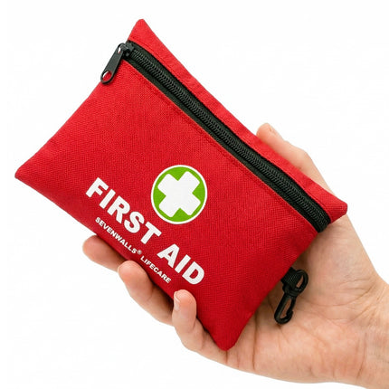 Red first aid kit with a visible brand logo held in a hand against a white background